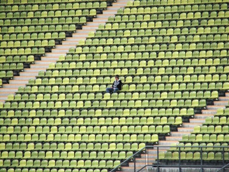 An adult sitting quietly alone on a couch, resting after a social gathering
