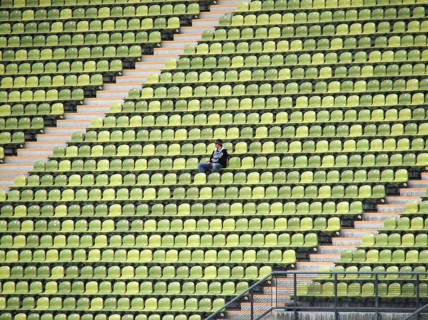 An adult sitting quietly alone on a couch, resting after a social gathering