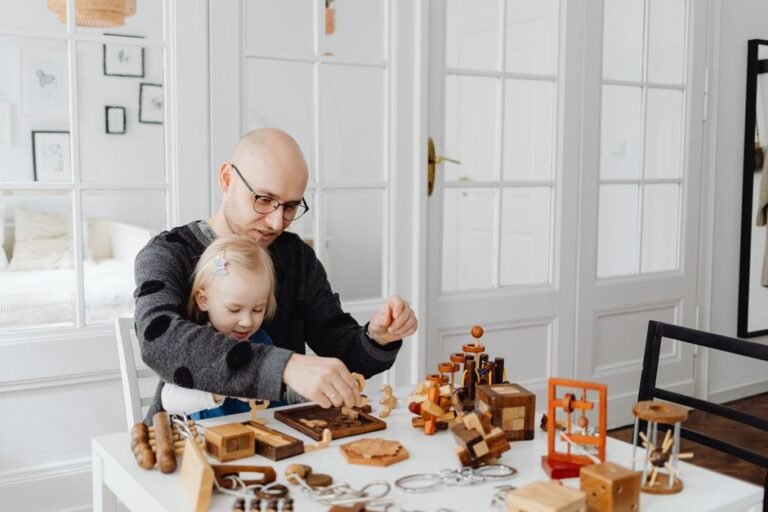 A child and an adult seated at a table together with wooden toys between them