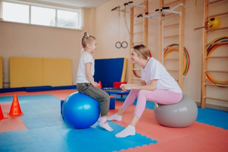 A child and a therapist using balance equipment together in a therapy room
