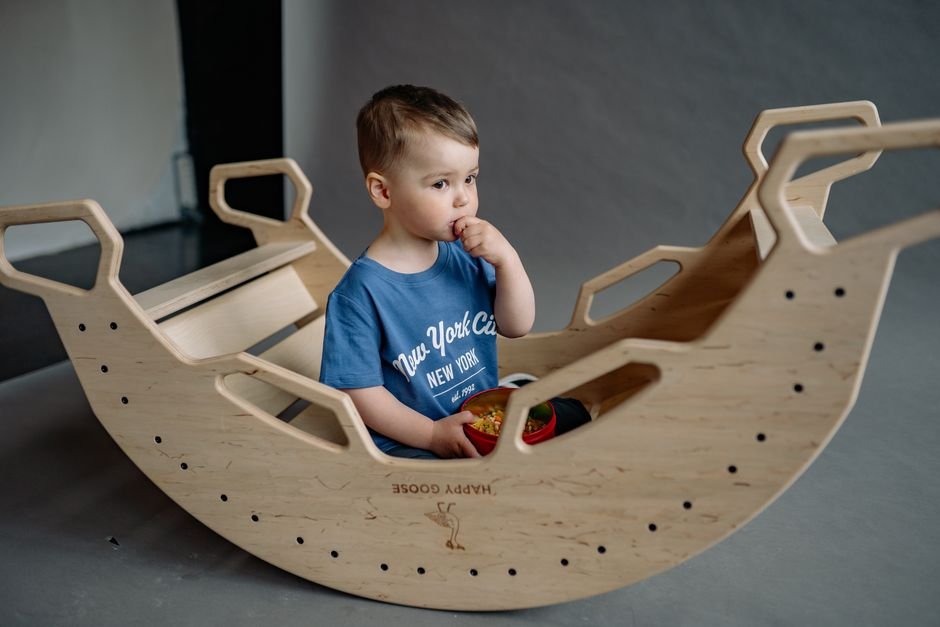 A child smiling while rocking gently during play