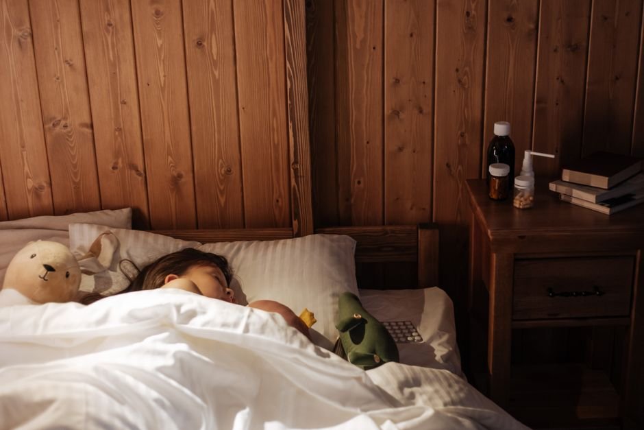 A child's bedroom at night with a soft nightlight and a visual bedtime chart on the wall
