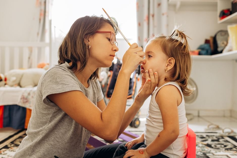 A child sitting calmly on the floor next to a caregiver.