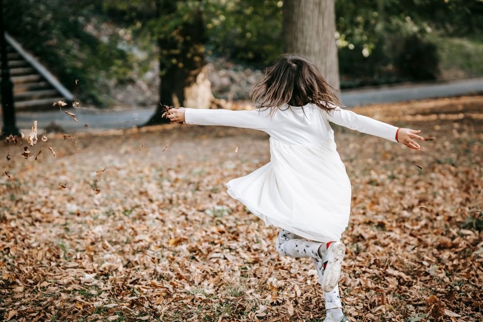 A child jumping happily on a trampoline outdoors.
