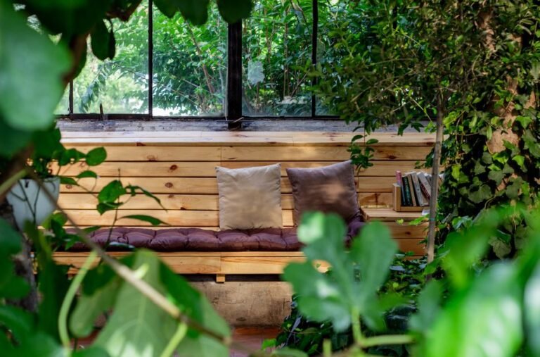 A small home corner with soft cushions, a blanket, and a low shelf of quiet toys, set apart from the main living space
