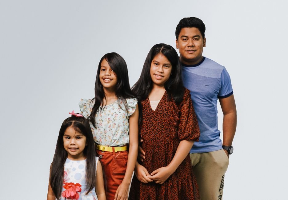 Getting an Autistic Child Ready for a Family Photo or Gathering A family of four smiling together outdoors while someone takes their photo
