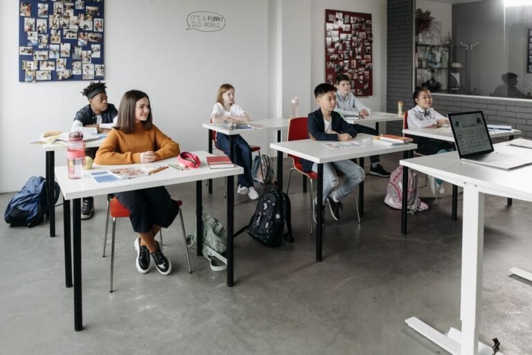 A communication notebook resting on a backpack next to a teacher's desk
