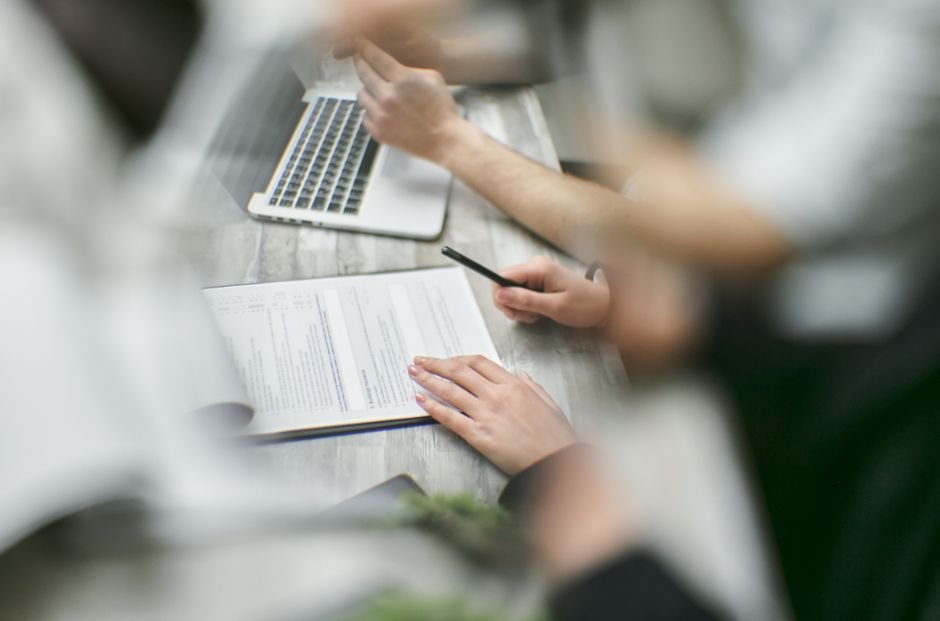 Where IEP-Related Health Discussions Often Go Sideways A parent and two school staff members sitting at a table looking over printed documents
