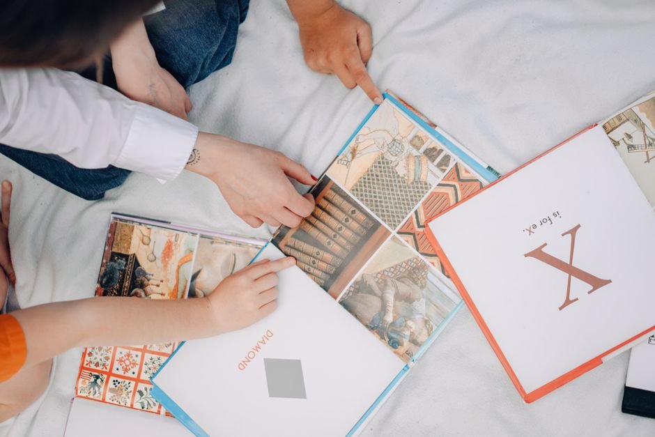 A parent and child looking together at a visual calendar on the wall