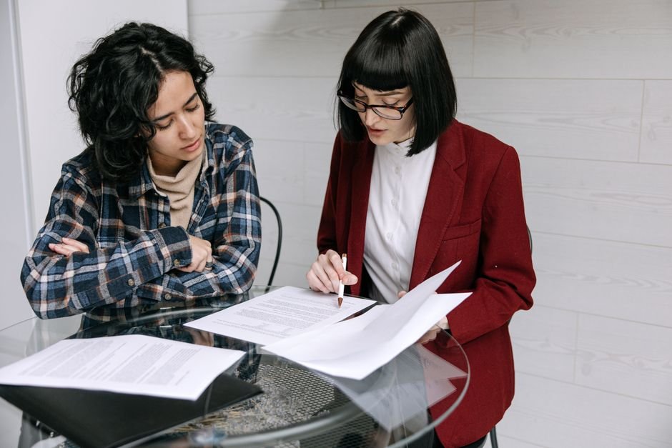 What an Advocate or Educational Consultant Actually Does Two adults sit at a kitchen table reading through a folder of printed documents together.