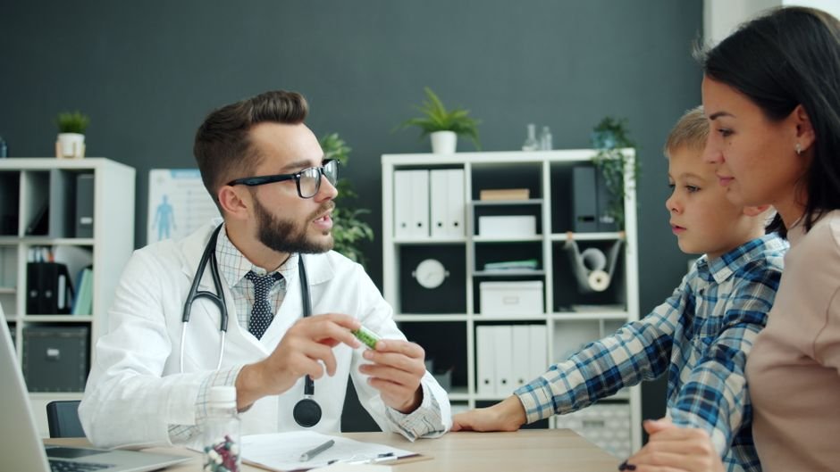 A parent sitting across from a doctor at a desk, talking during an appointment