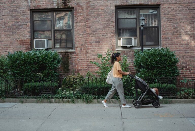 A parent and child walking hand in hand toward a school entrance