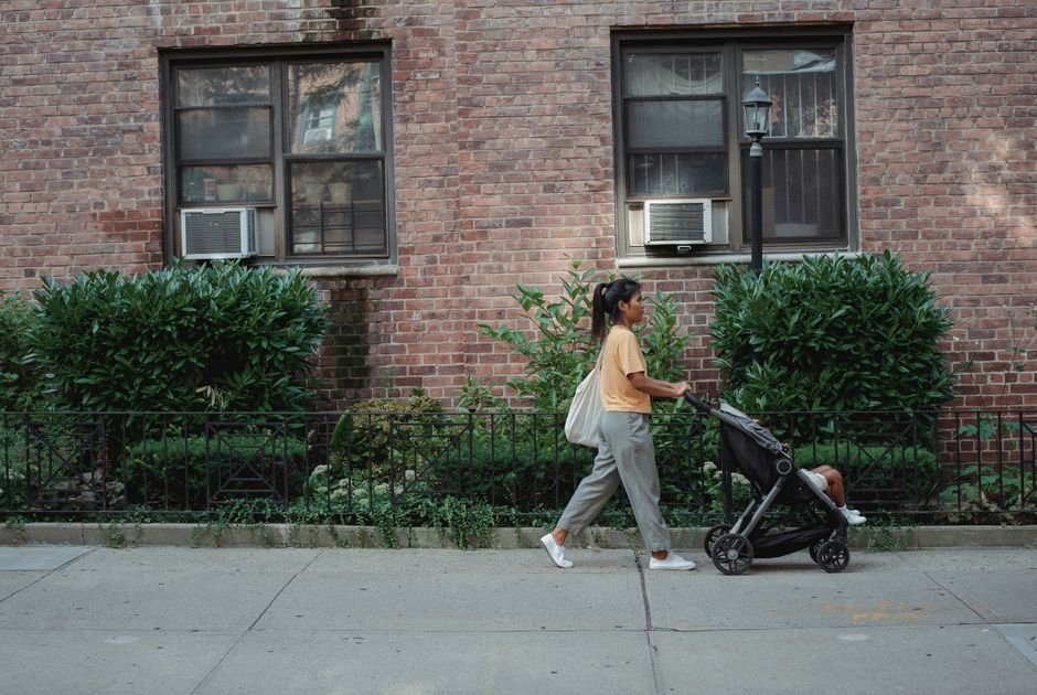 A parent and child walking hand in hand toward a school entrance