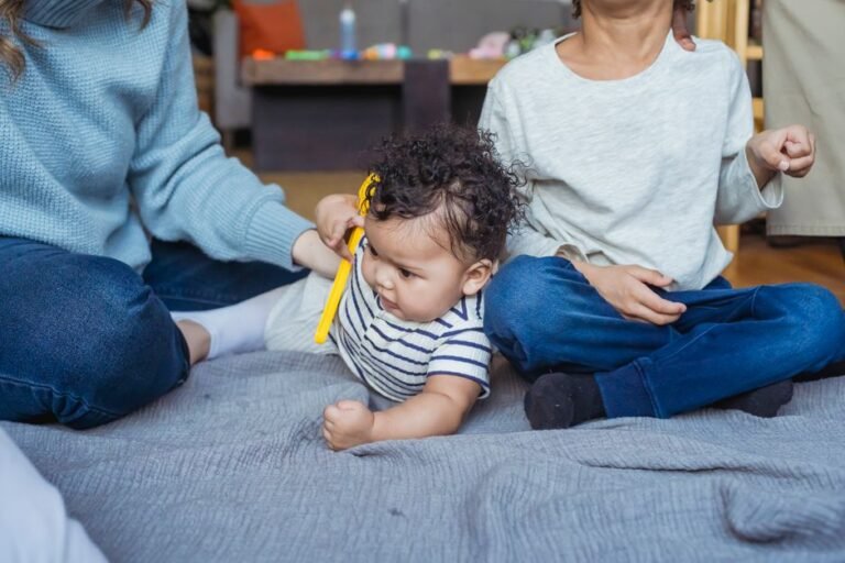 Two siblings sitting on the floor together, playing with toys