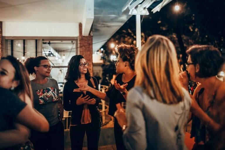 A small group of adults talking and smiling together at a community event.