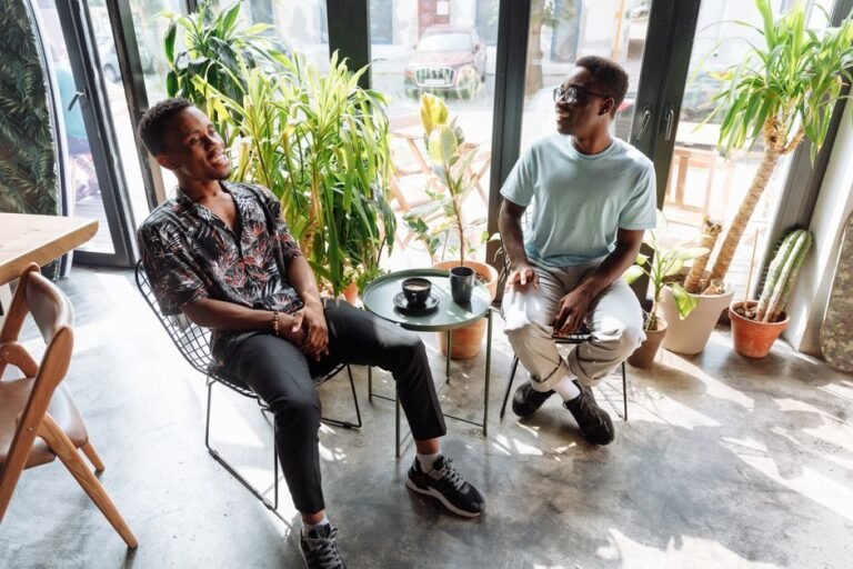 Two adults sitting together outdoors having a relaxed conversation
